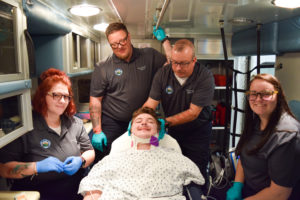 Photo of WPCC Emergency Medical Technician Students posing in the training ambulance